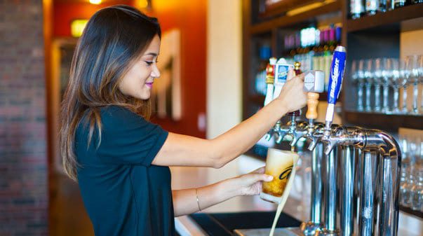 Bartender filling up beer glass